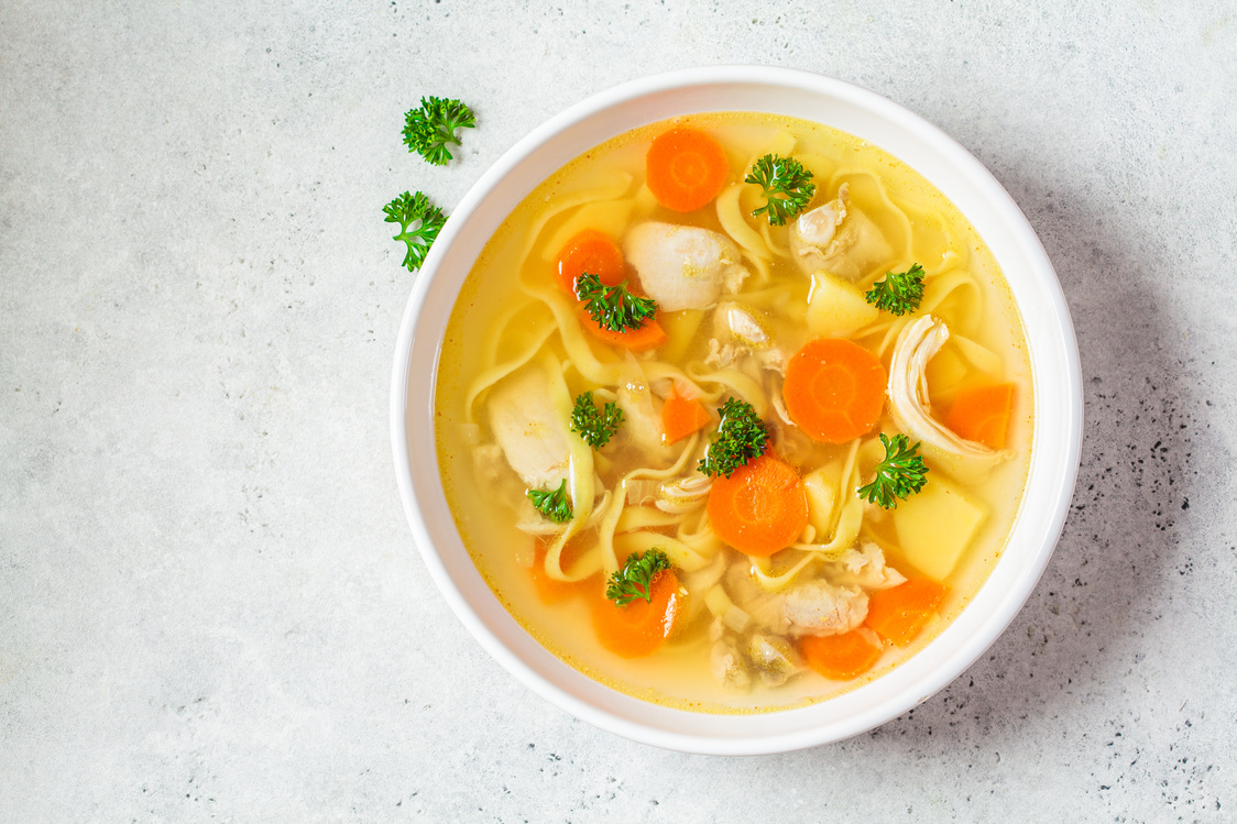 Chicken Soup with Noodles and Vegetables in White Bowl