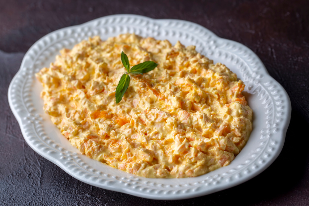 Traditional delicious Turkish foods; Fresh carrot salad with garlic yogurt in bowl. ( Turkish name; havuc tarator) Carrot tarator in ceramic bowl with vegetable on dark background.