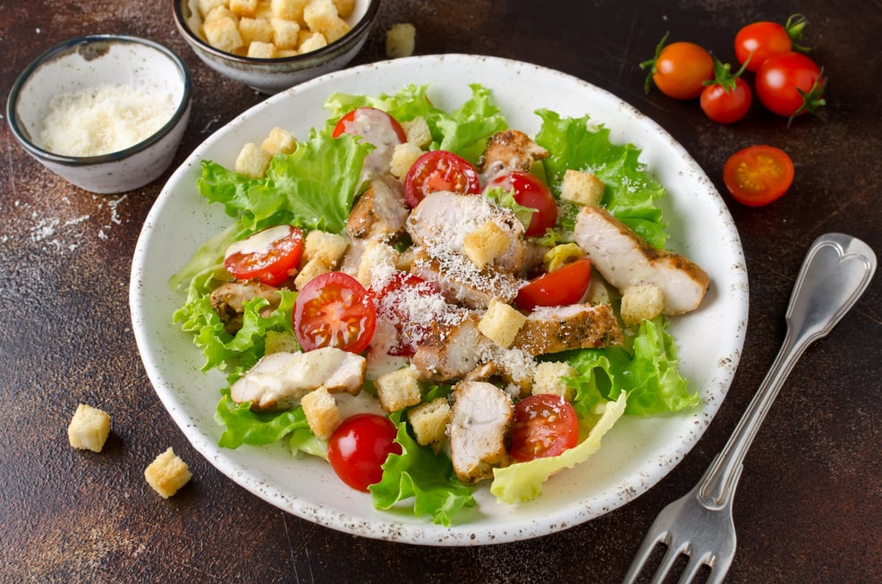 Caesar salad with chicken, tomatoes, Parmesan and croutons